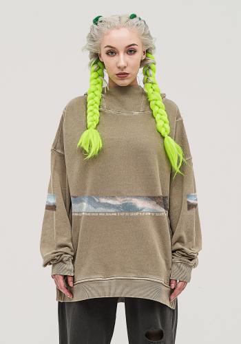 Produktfoto mit Link: Weibliches Model mit neongrünen Zöpfen von vorn trägt einen hellbraunen Kapuzenpullover mit 