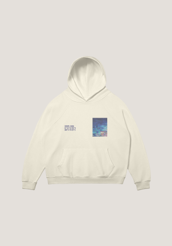 Flatlay-Aufnahme eines hellbeigen Kapuzenpullovers mit warmem Gelbstich vor neutral-beigem Hintergrund. Der Kapuzenpullover zeigt die Küstenregion der Stadt 