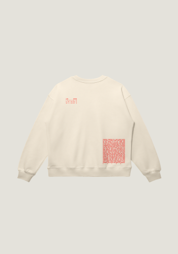 Produktfoto mit Link: Flatlay-Aufnahme der Rückseite eines beigen Pullovers vor neutral-beigem Hintergrund. Der Rücken ist mit rotem Text bedruckt. Ein Text erzählt von den Flamingos, die im Natronsee in Tansania leben (rechts unten auf dem Pullover) und ein Text zeigt die Koordinaten des Ortes (links oben an der Schulter des Pullovers) Produkt namens 